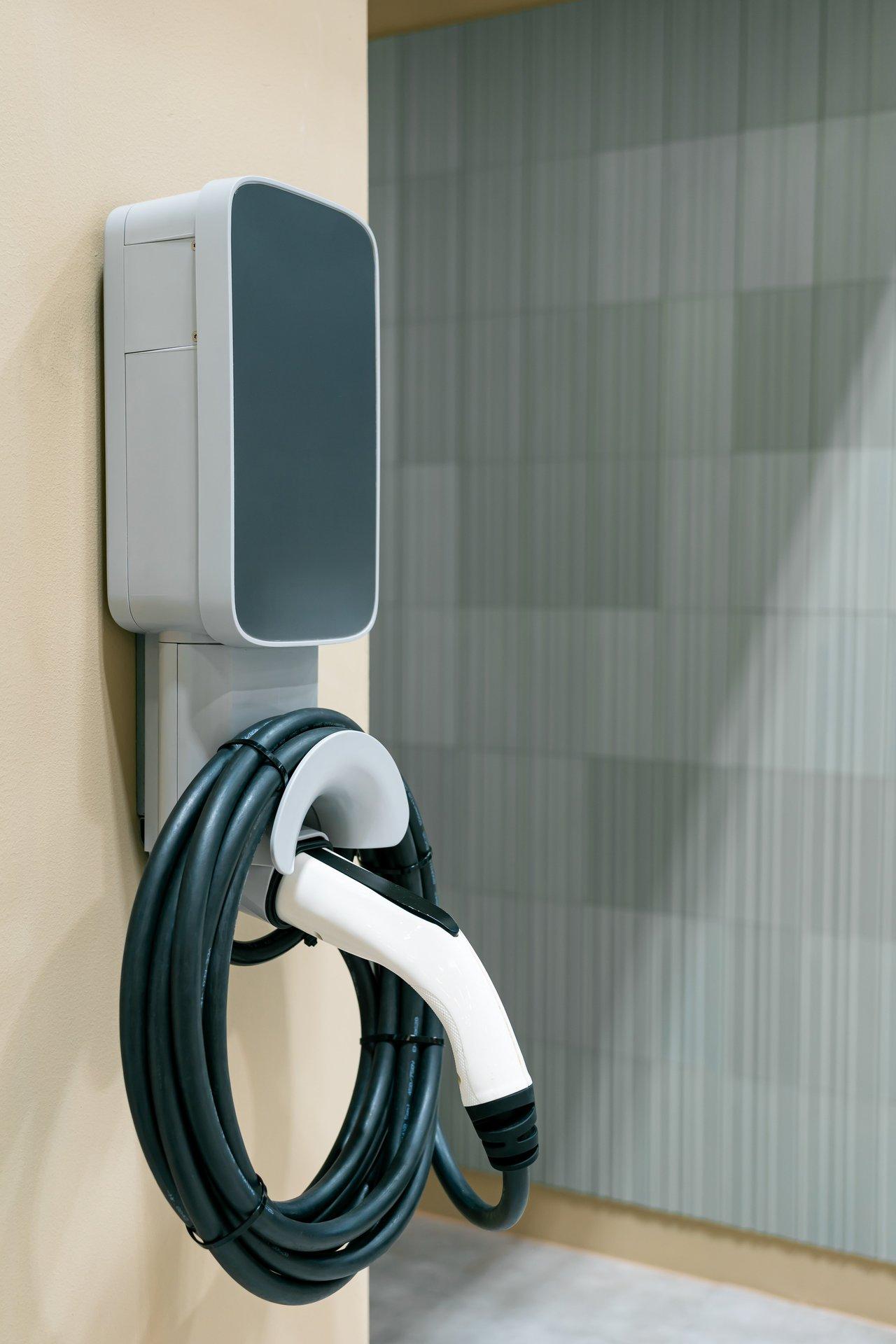 Borne de recharge électrique dans un garage moderne, essentielle pour l'installation d'une voiture électrique à domicile.