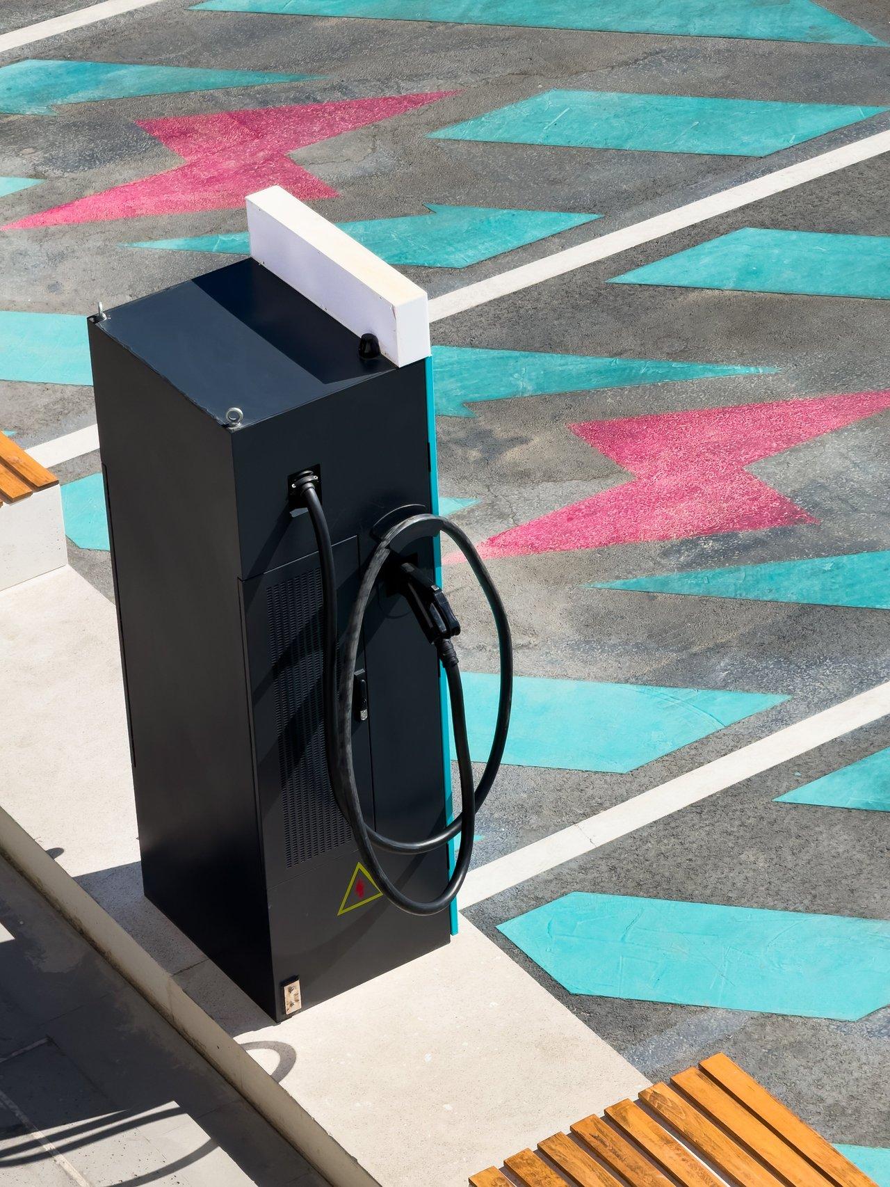 Borne de recharge électrique urbaine moderne pour véhicules électriques dans un centre commercial.