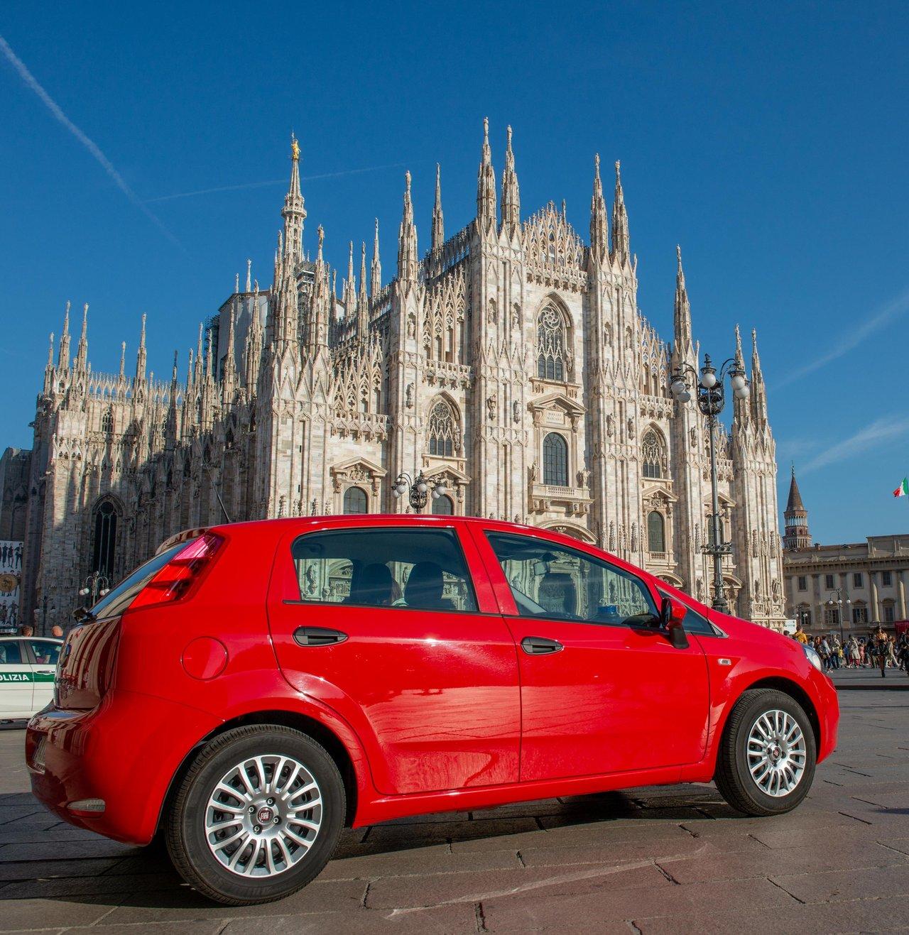 Cabriolet électrique rouge en milieu urbain à Milan, parfait pour rouler cheveux au vent.