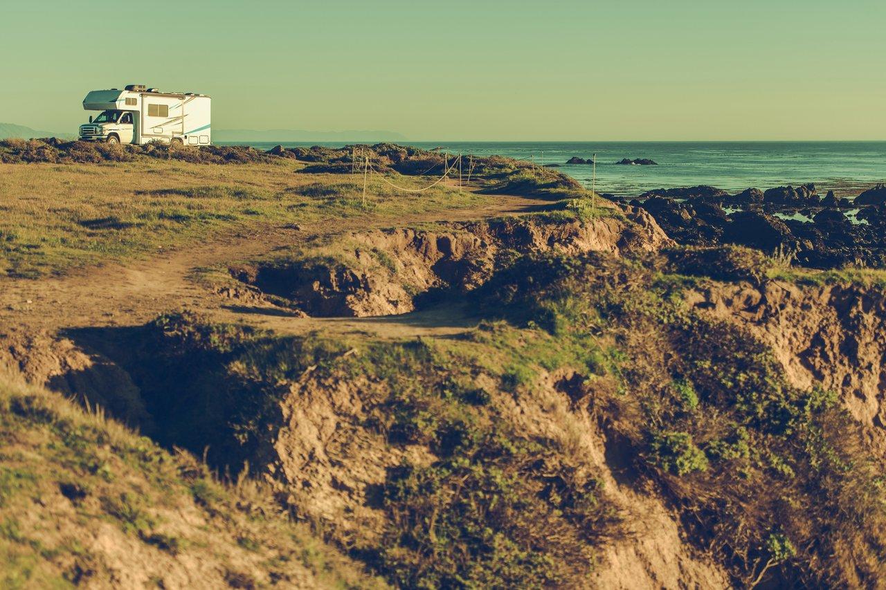 Campervan face aux falaises escarpées de la Pointe du Raz, face à l’océan agité, idéale pour un road trip en camping-car.