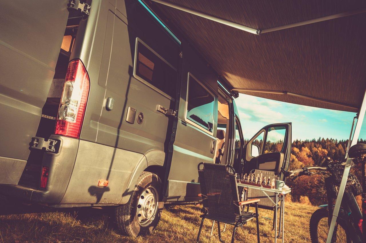 Camping-car profilé moderne dans une aire de repos en pleine nature, idéal pour un voyage en toute liberté.
