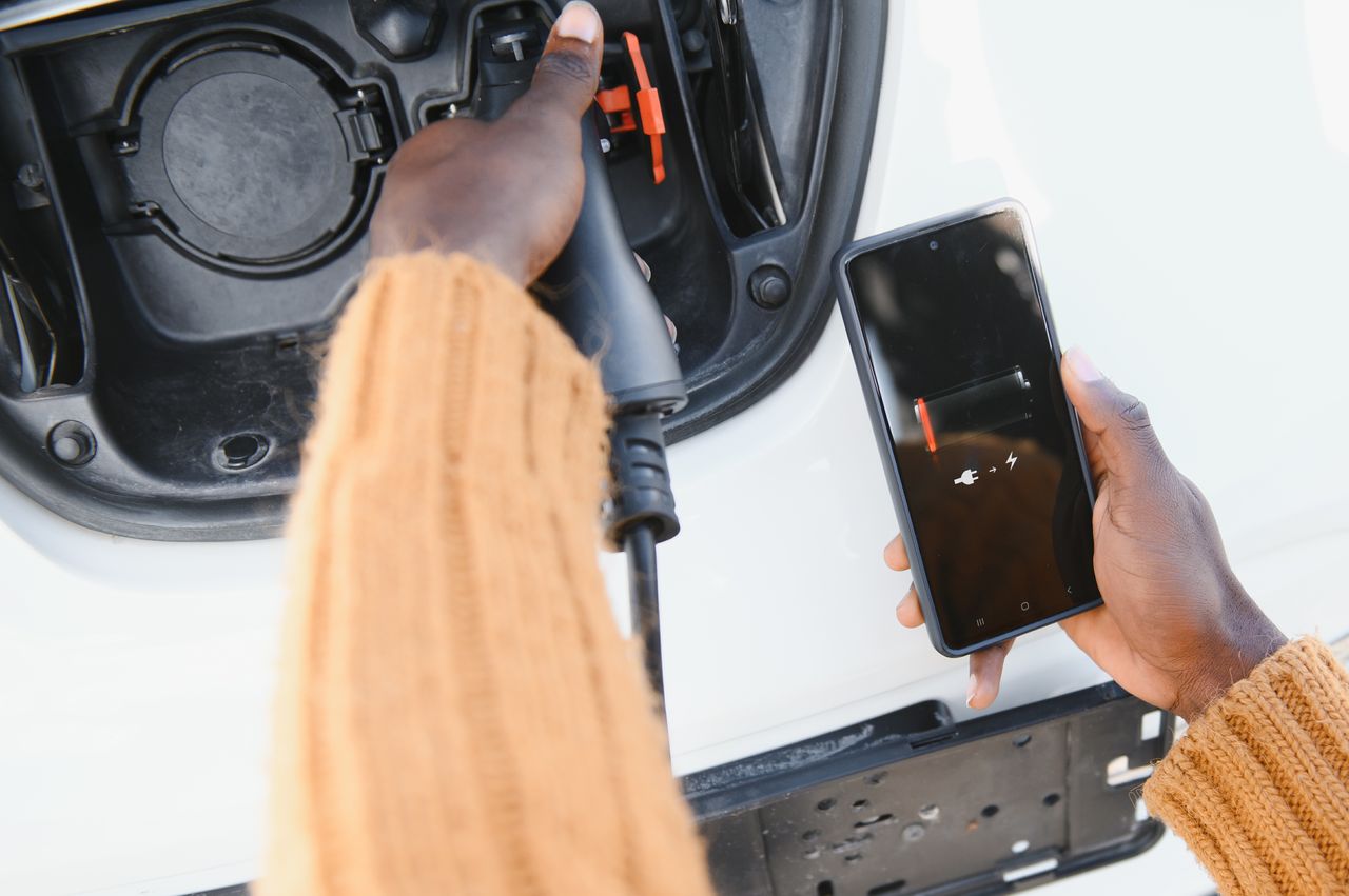 Chargeur sans fil Qi2 15W fixé en voiture, smartphone aimanté en recharge rapide sur tableau de bord.