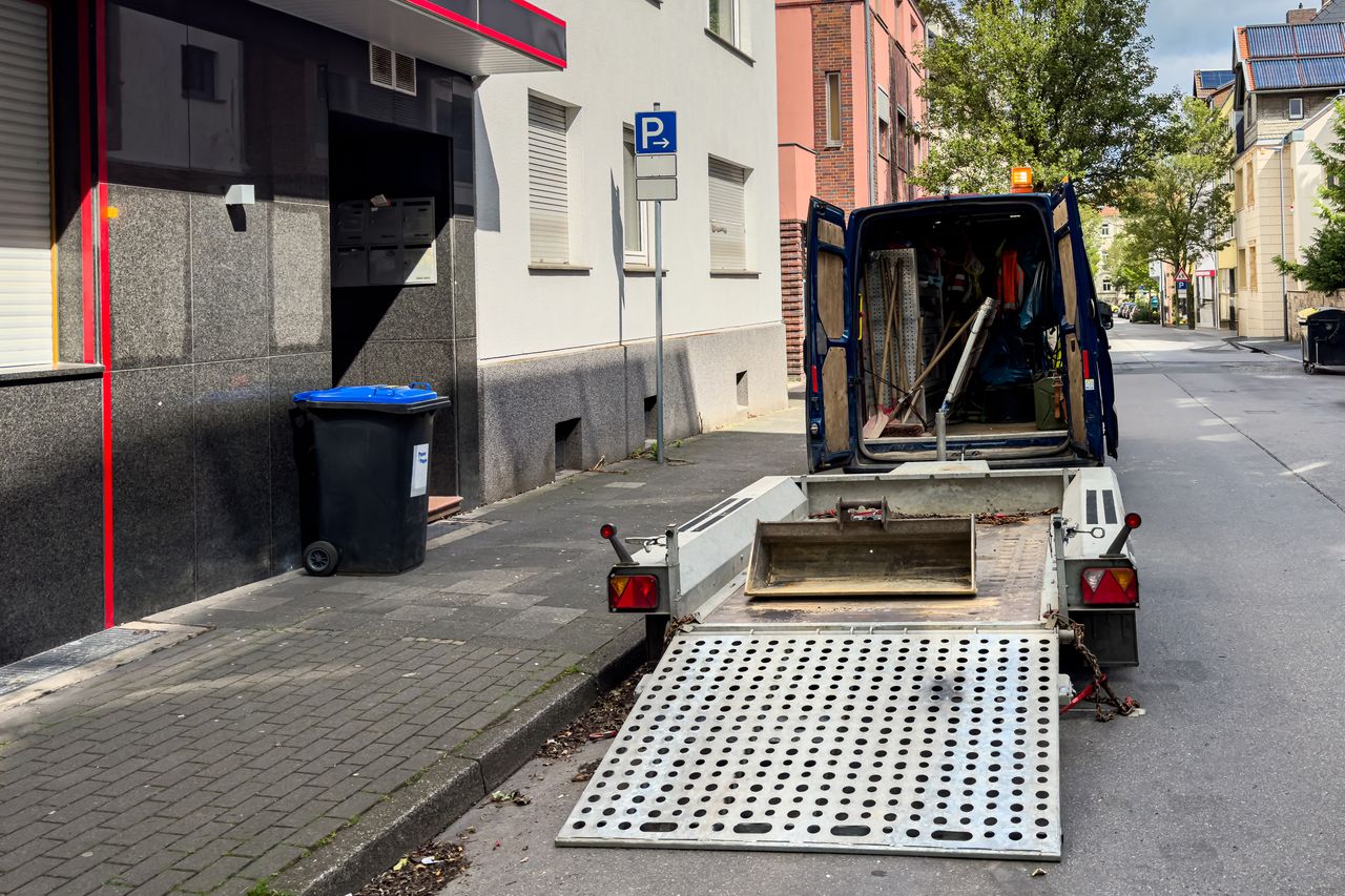 Circulation urbaine sous panneaux ZFE avec voiture Crit'Air, livraison et immeubles de centre-ville en arrière-plan.