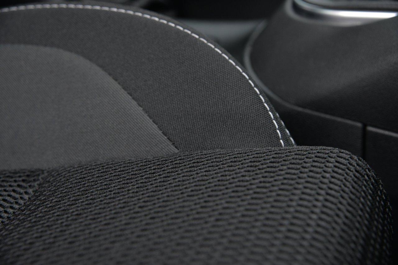 Détail de coussins ergonomiques pour sièges auto, alliant texture noire et coutures blanches pour un confort optimal.