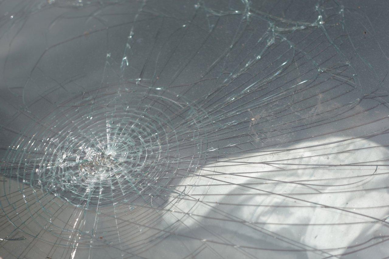 Détail d'un pare-brise endommagé avec impact visible avant réparation, illustrant la nécessité d’évaluation.