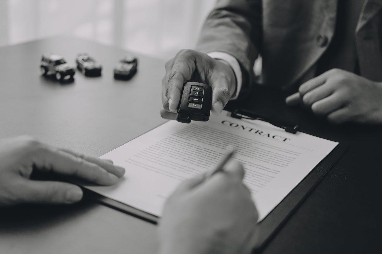 Documents de vente de véhicule : certificat de cession, carte grise barrée et contrôle technique sur une table.