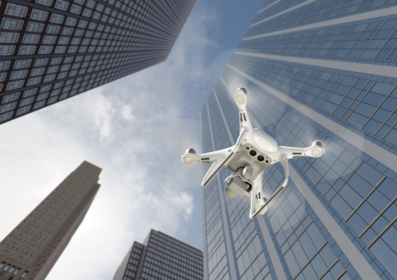 Drone taxi en phase d’atterrissage sur un vertiport urbain moderne avec la skyline en arrière-plan.