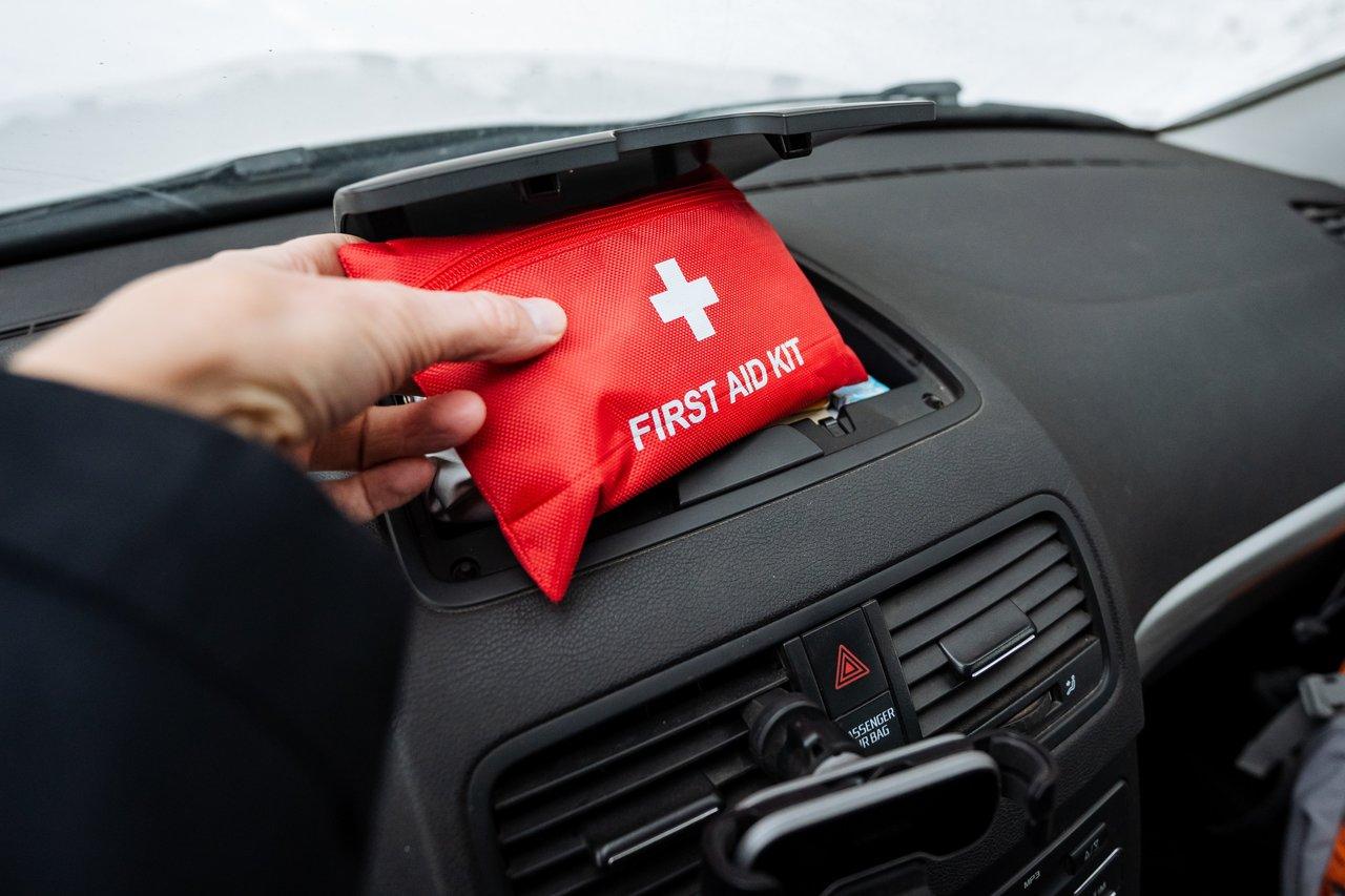 Équipements de sécurité d'urgence dans une voiture : triangle, gilet et kit de premiers secours prêts à l'emploi.