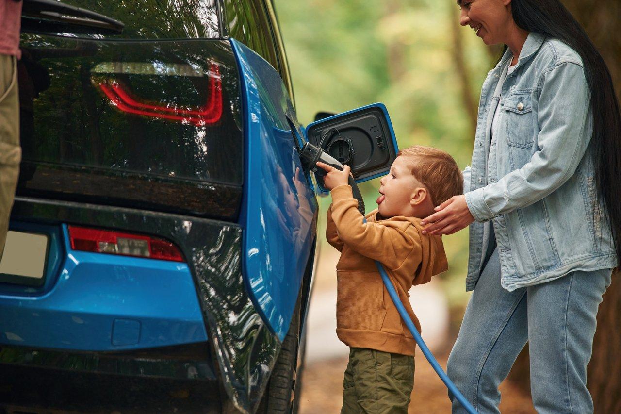Famille en zone périurbaine rechargeant une voiture électrique pour favoriser une mobilité verte.
