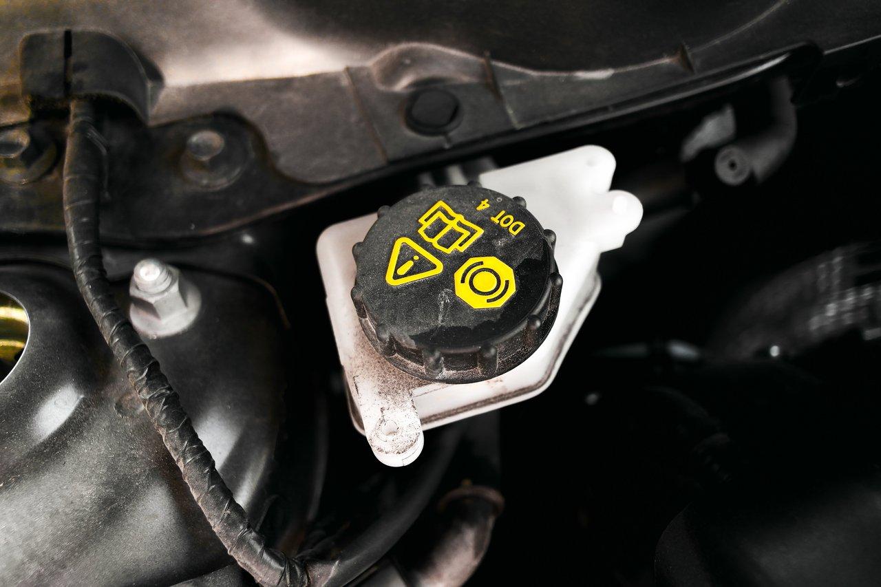 Fuite de liquide de frein visible sous la voiture, soulignant l'importance d'une inspection régulière pour votre sécurité.