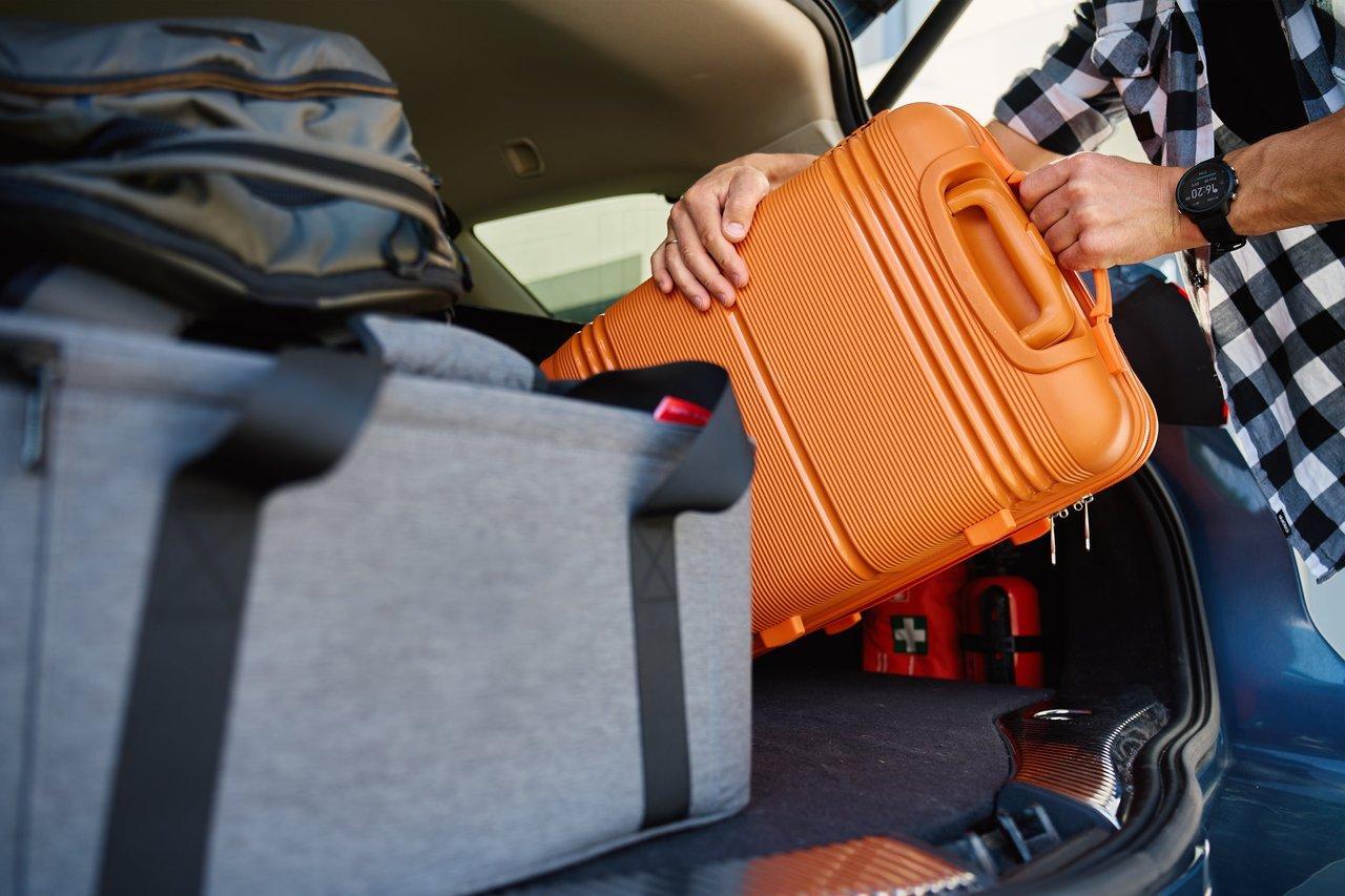 Glacière portable dans le coffre d’une voiture, essentielle pour voyager sereinement en été.