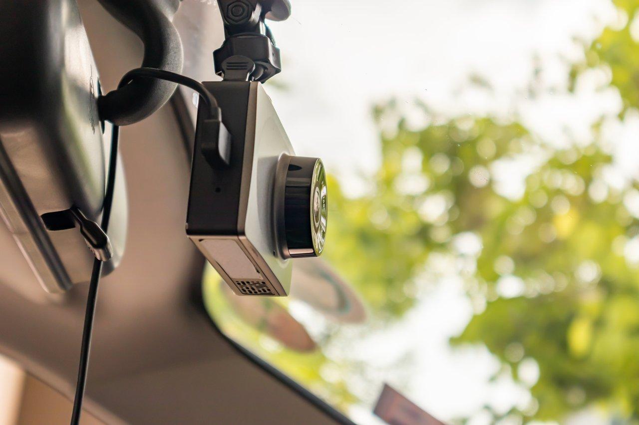 Installation discrète d’une dashcam cachée derrière le rétroviseur intérieur pour une sécurité optimale.