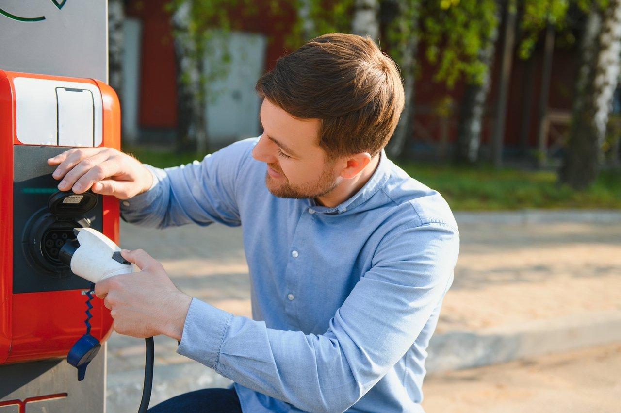 Installation d'une borne de recharge murale 7 kW avec écran dans un garage domestique, facilitant la charge électrique.