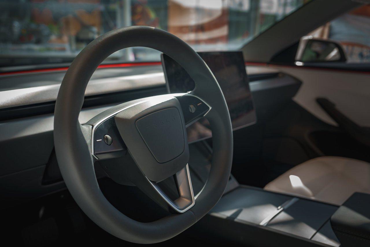 Intérieur de la Tesla Model 3 2025 avec toit panoramique et écran arrière passagers, alliant luxe et innovation.