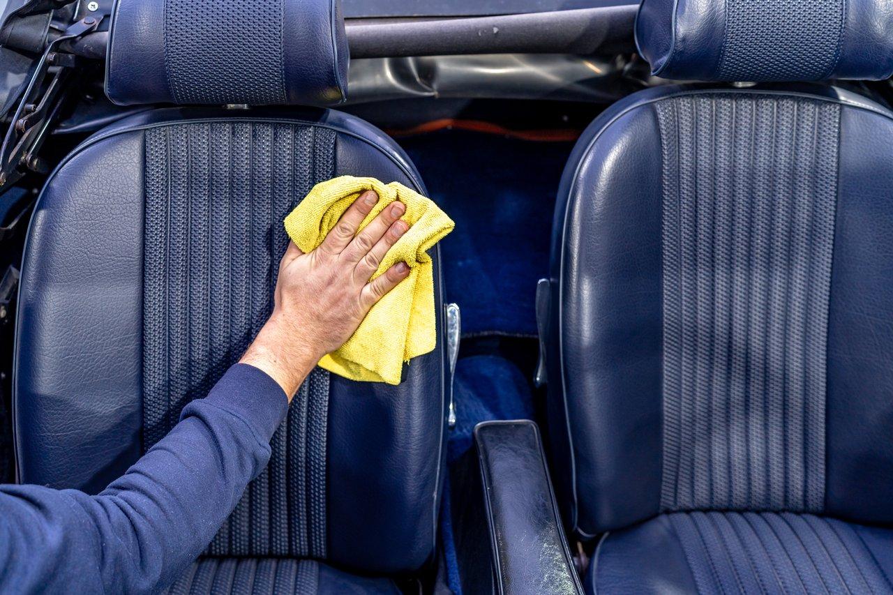 Intérieur de voiture propre avec sièges en cuir et tissus, ciel de toit et tableau de bord impeccables pour un nettoyage professionnel.