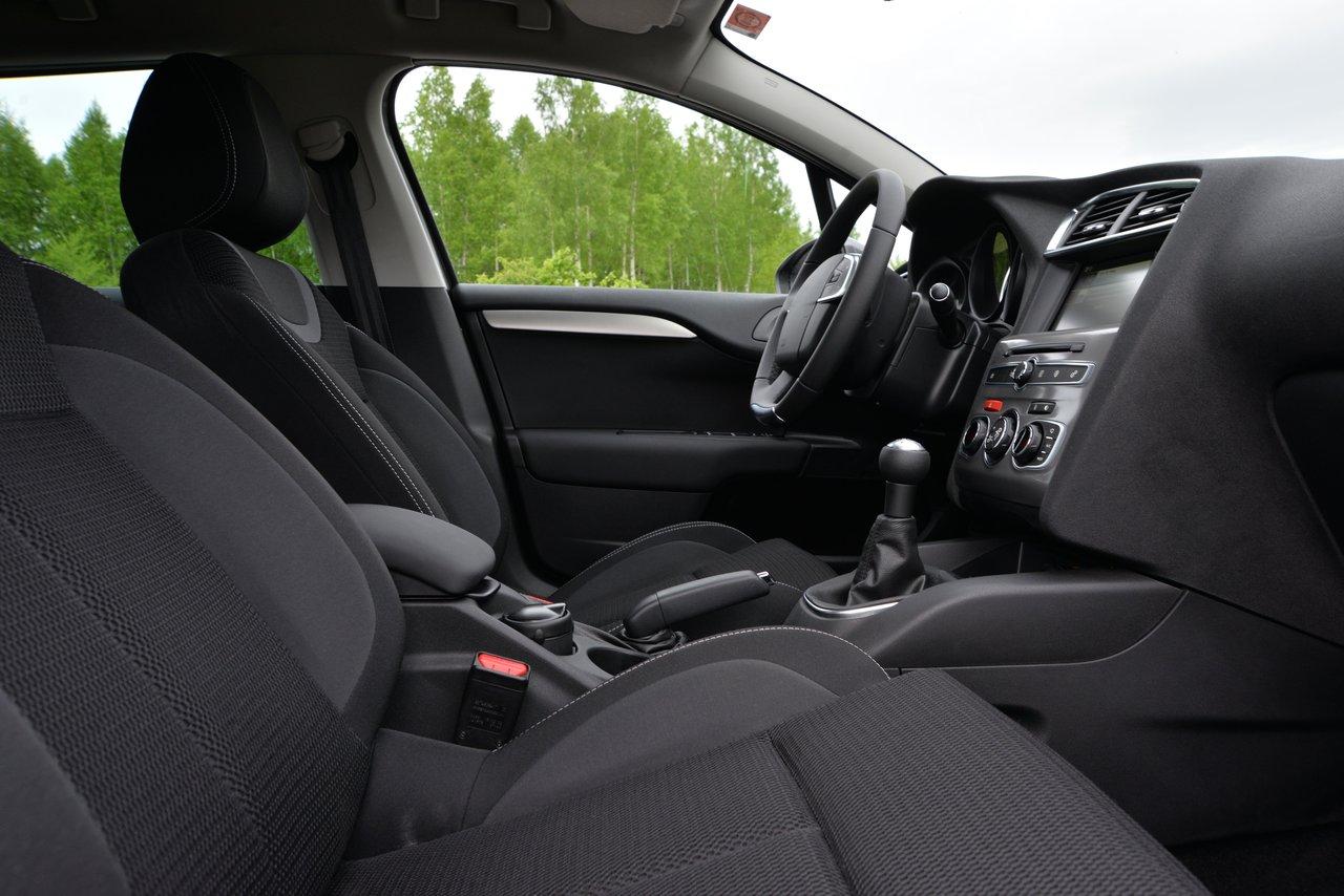 Intérieur d'une voiture électrique sportive avec sièges baquets chauffants et tableau de bord moderne.