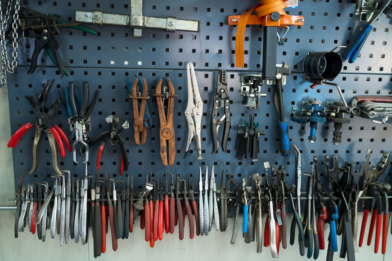Jante aluminium grise rayée en atelier, outils de réparation organisés et éclairage net pour restauration professionnelle.
