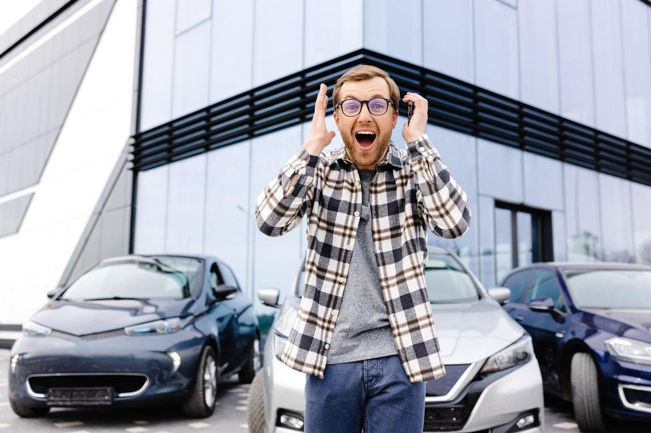 Jeune conducteur inspectant une voiture d’occasion en extérieur, symbole d’un choix réfléchi et satisfaisant.