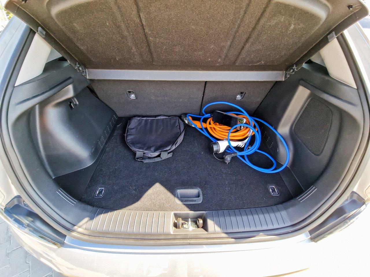 L’intérieur du coffre spacieux du Kia e-Niro 2020, avec câbles de recharge et espace modulable.