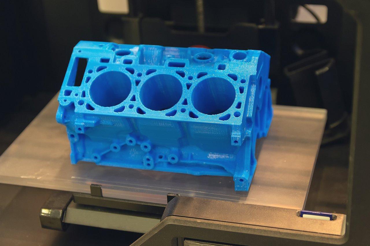 Modèle de bloc moteur imprimé en 3D illustrant la fabrication automobile innovante et écologique.