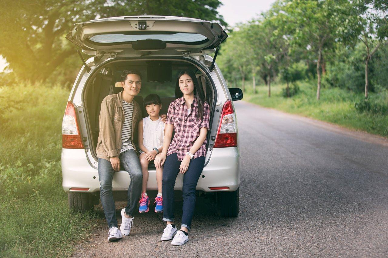 Moment de détente en famille lors d'une pause sur la route, sous une assurance auto adaptée pour une sérénité totale.