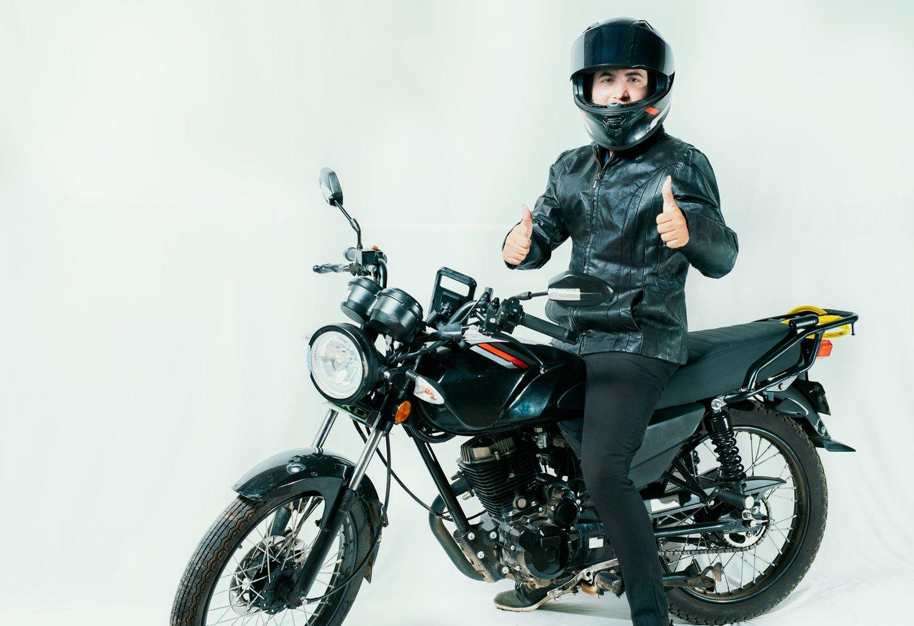 Motard et passager équipés en sécurité avec casque intégral et blouson renforcé pour une conduite en toute sécurité.