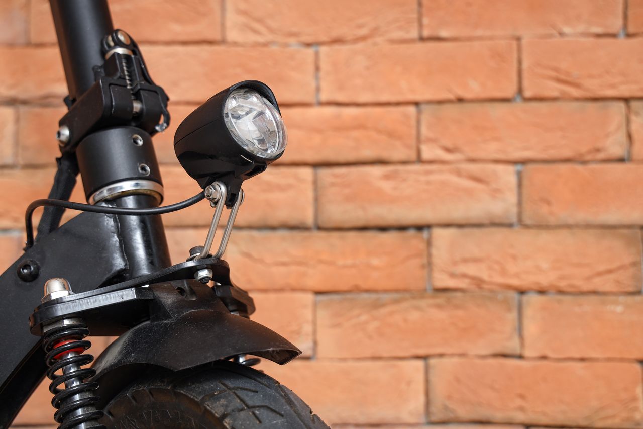 Moto électrique hivernée en garage, batterie sortie et mainteneur de charge connecté pour conservation optimale.