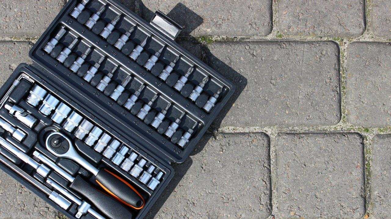 Outils de maintenance pour moto organisés dans une boîte en plastique, essentiels pour l’entretien de votre deux-roues.
