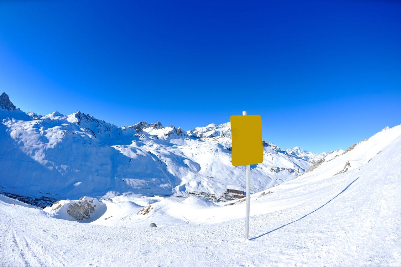 Panneau d'obligation pour chaînes à neige en montagne enneigée, garantissant sécurité et conformité en hiver 2025.