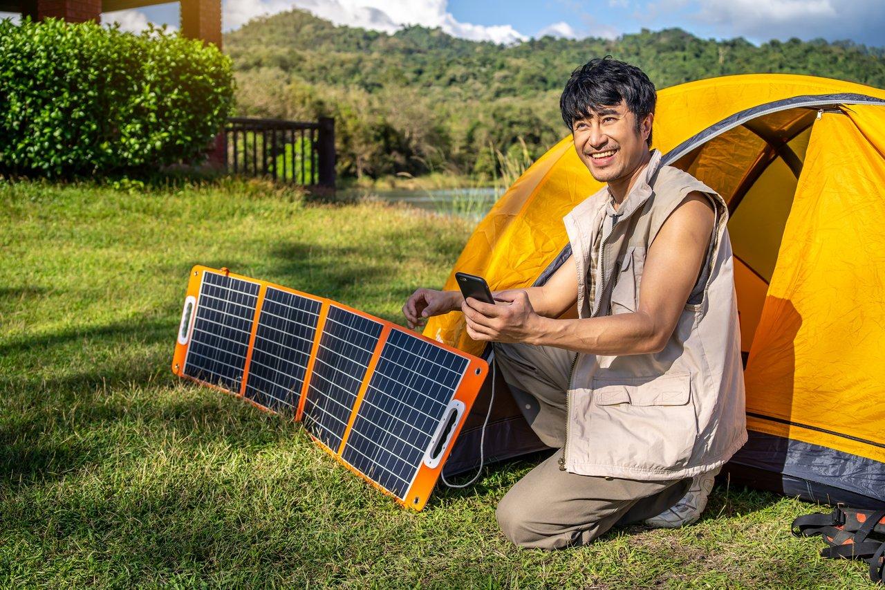 Panneaux solaires monocristallins sur camping-car avec affichage smartphone du BMS pour une autonomie optimale.