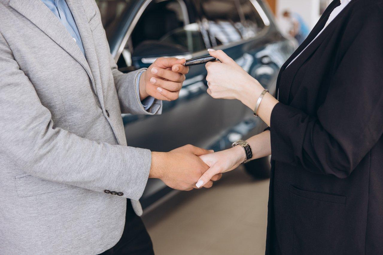 Remise des clés d'une voiture de leasing lors d'une transaction dans une concession moderne.