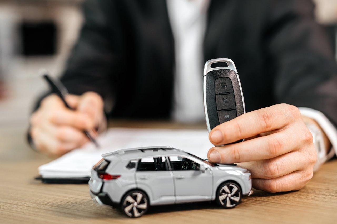 Remise des clés et signature du contrat d'assurance pour une nouvelle voiture, symbole d'une acquisition sécurisée.