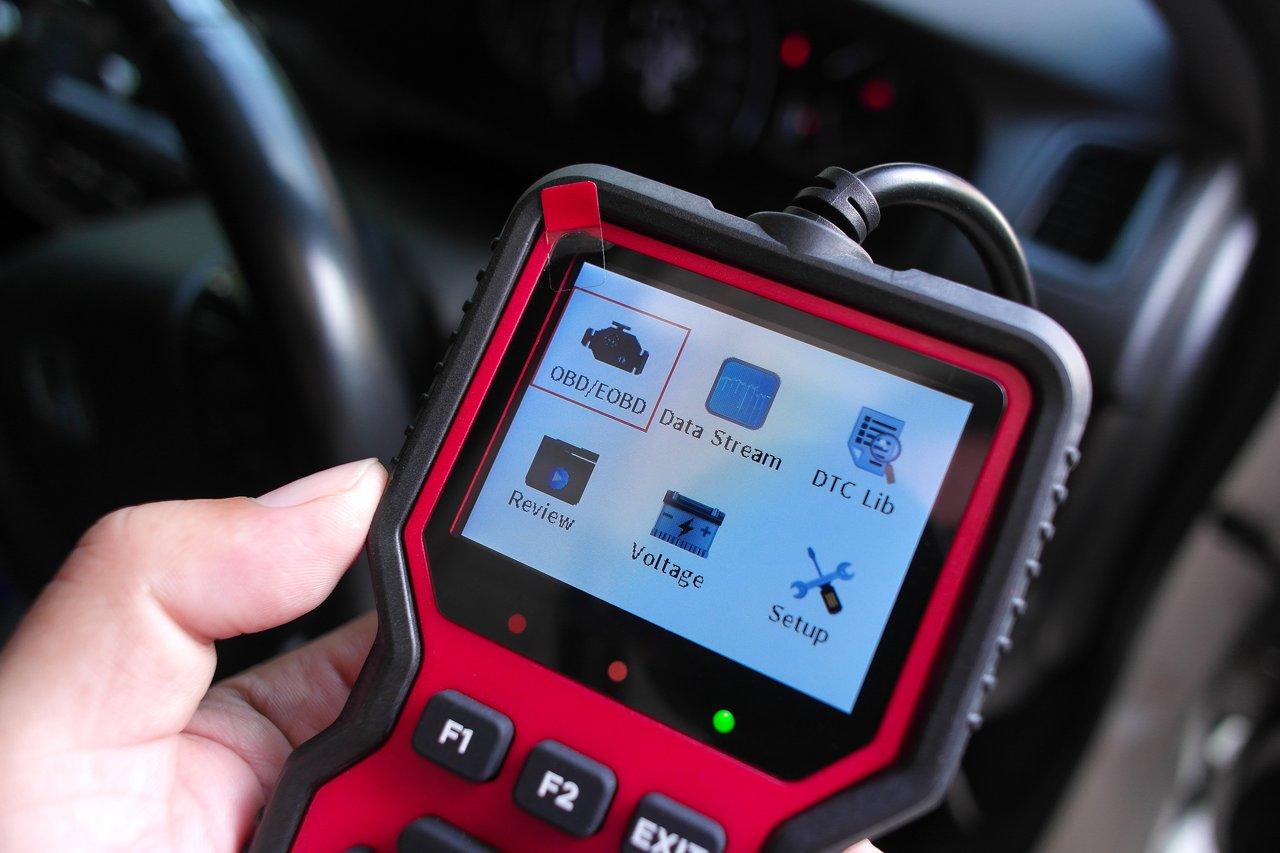Scanner OBD connecté à la prise de diagnostic pour vérifier le kilométrage et l’état du véhicule.