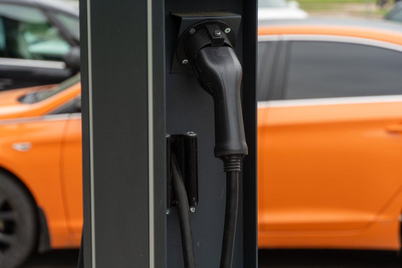 Station de recharge pour voiture électrique en milieu urbain, illustrant l'importance de l'infrastructure de recharge.