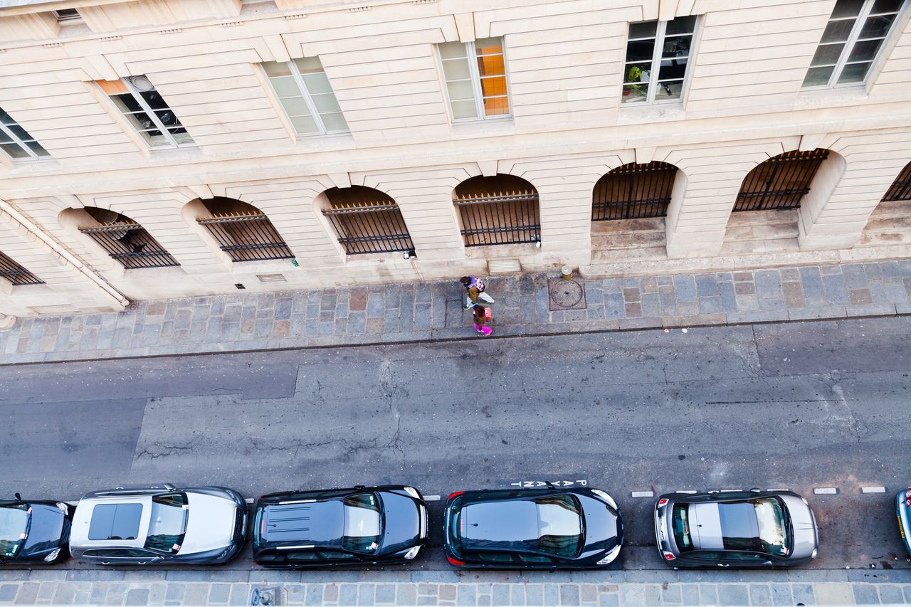 Trois voitures d’autopartage alignées près d’une borne à Paris, ambiance urbaine et mobilité partagée.