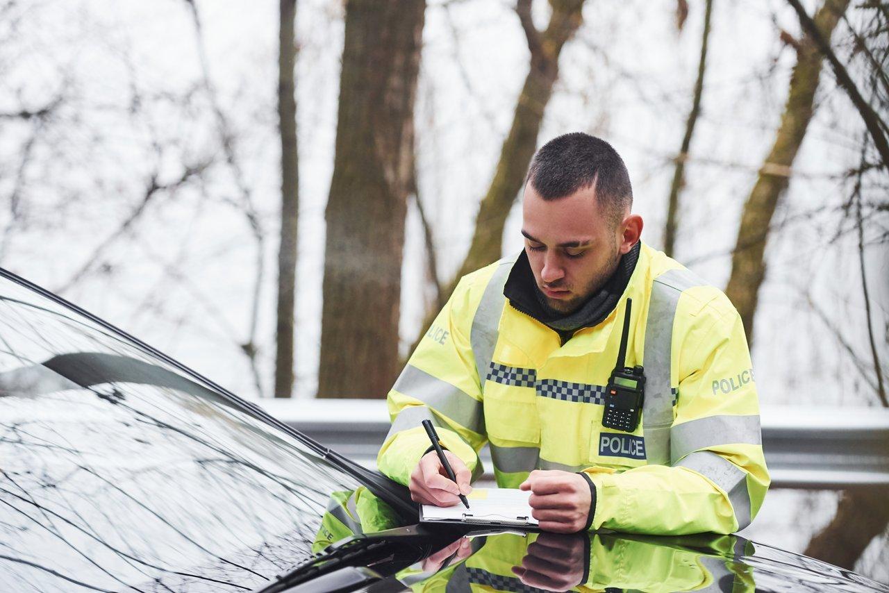 Un agent de police vérifie les documents du véhicule lors d’un contrôle routier avec un traffic police document check.