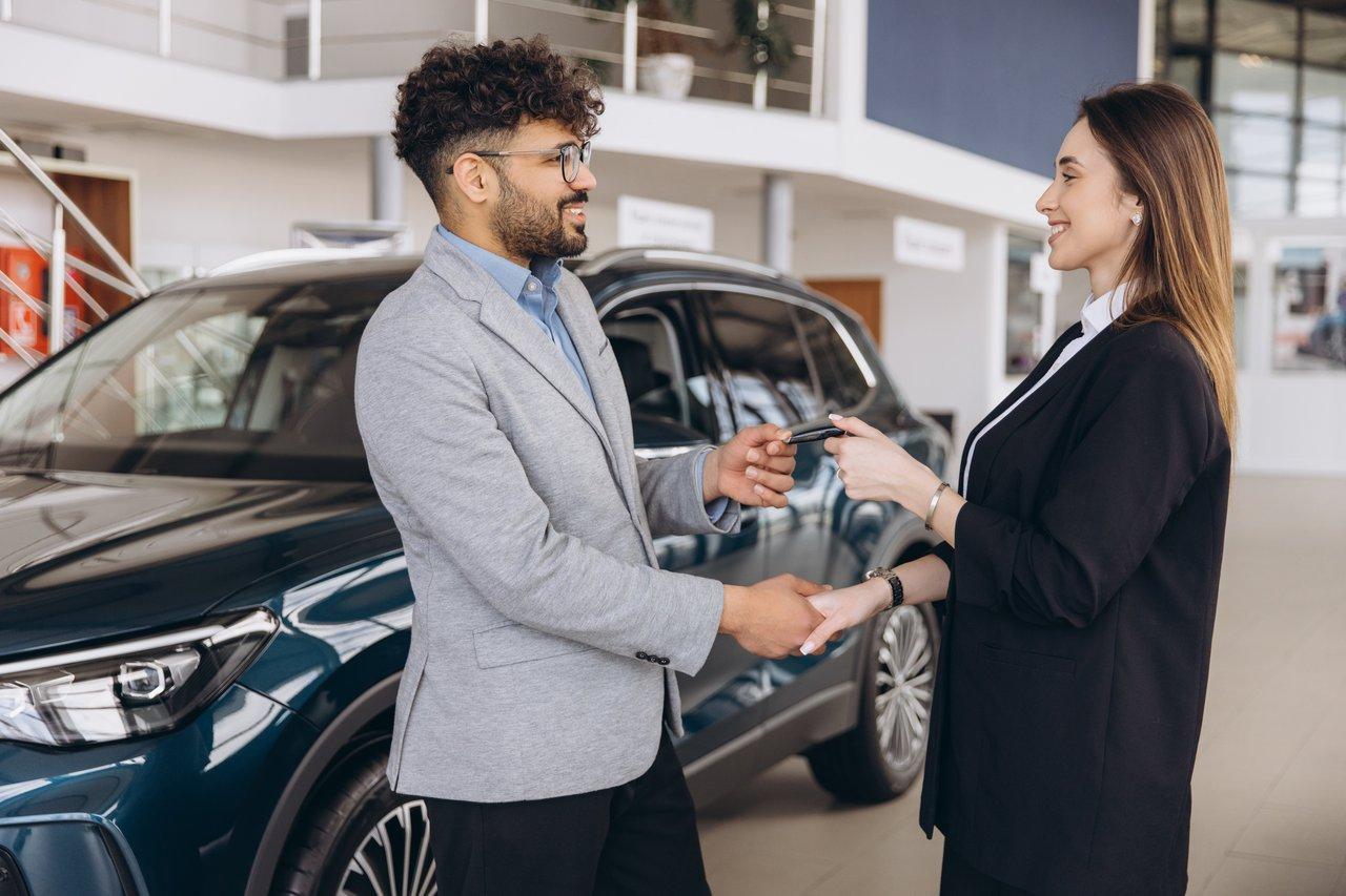 Un client satisfait recevant les clés d'une voiture commandée via un mandataire automobile.