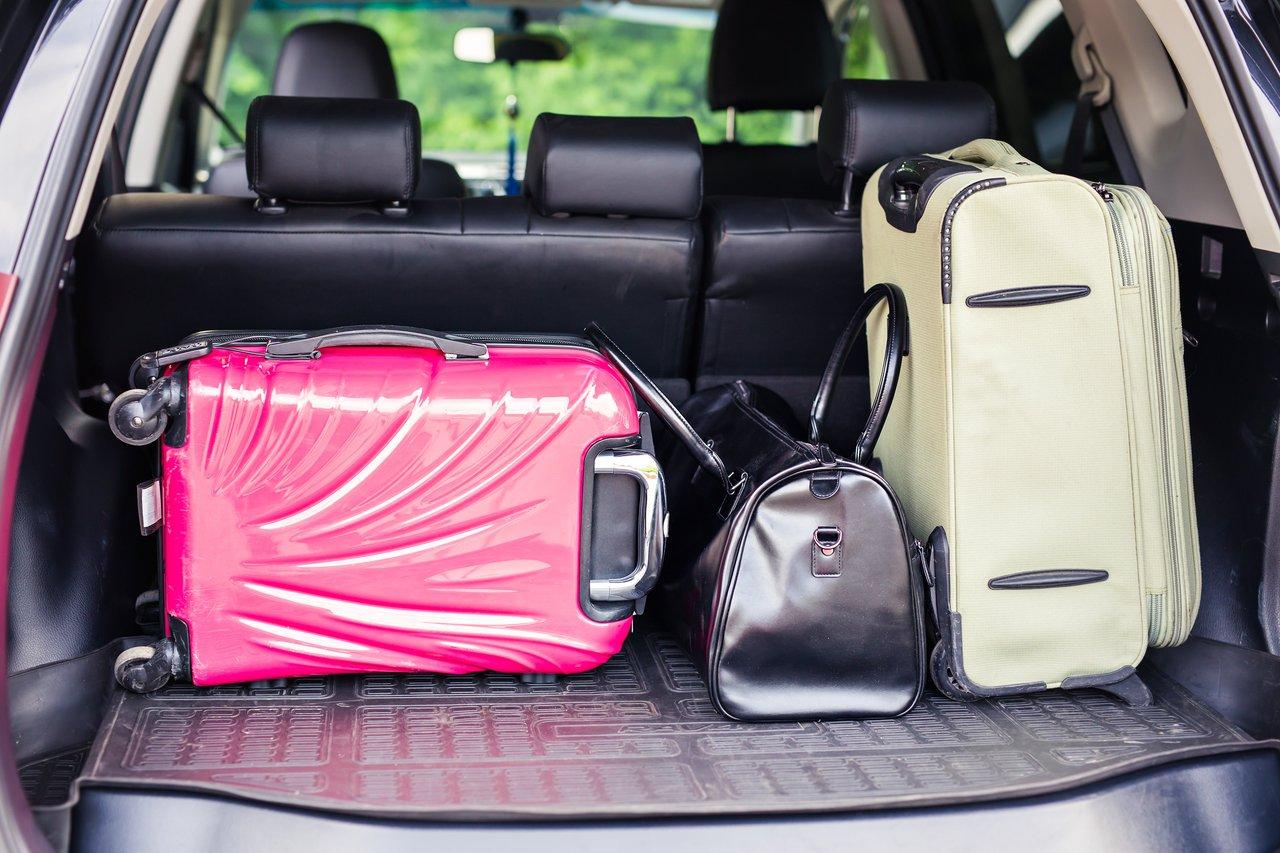 Un coffre bien organisé avec sacs compressibles et checklist pour un chargement optimal avant le départ.