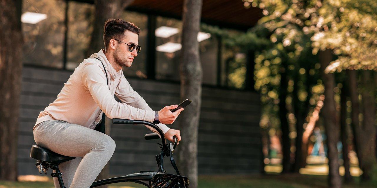 Un cycliste urbain utilisant une application de navigation pour planifier un itinéraire combinant vélo, métro et bus.