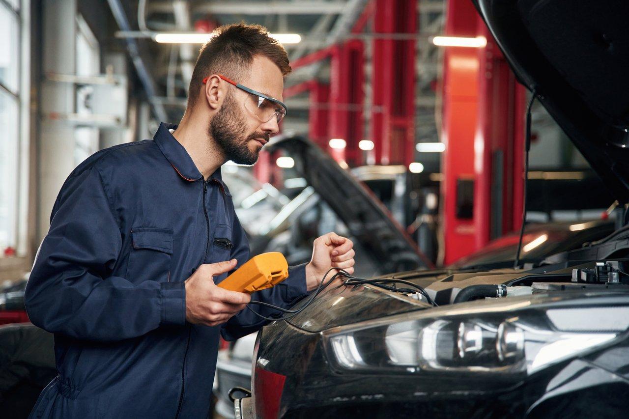 Un expert automobile effectue un diagnostic électronique complet pour évaluer la fiabilité d’un véhicule d’occasion.