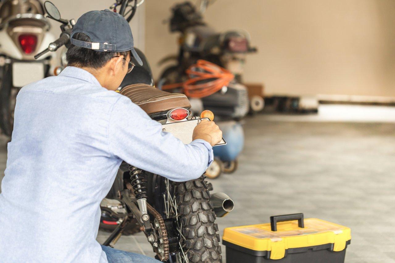 Un mécanicien réalise l’entretien basique d’une moto lors d’un workshop de maintenance motorcycle.