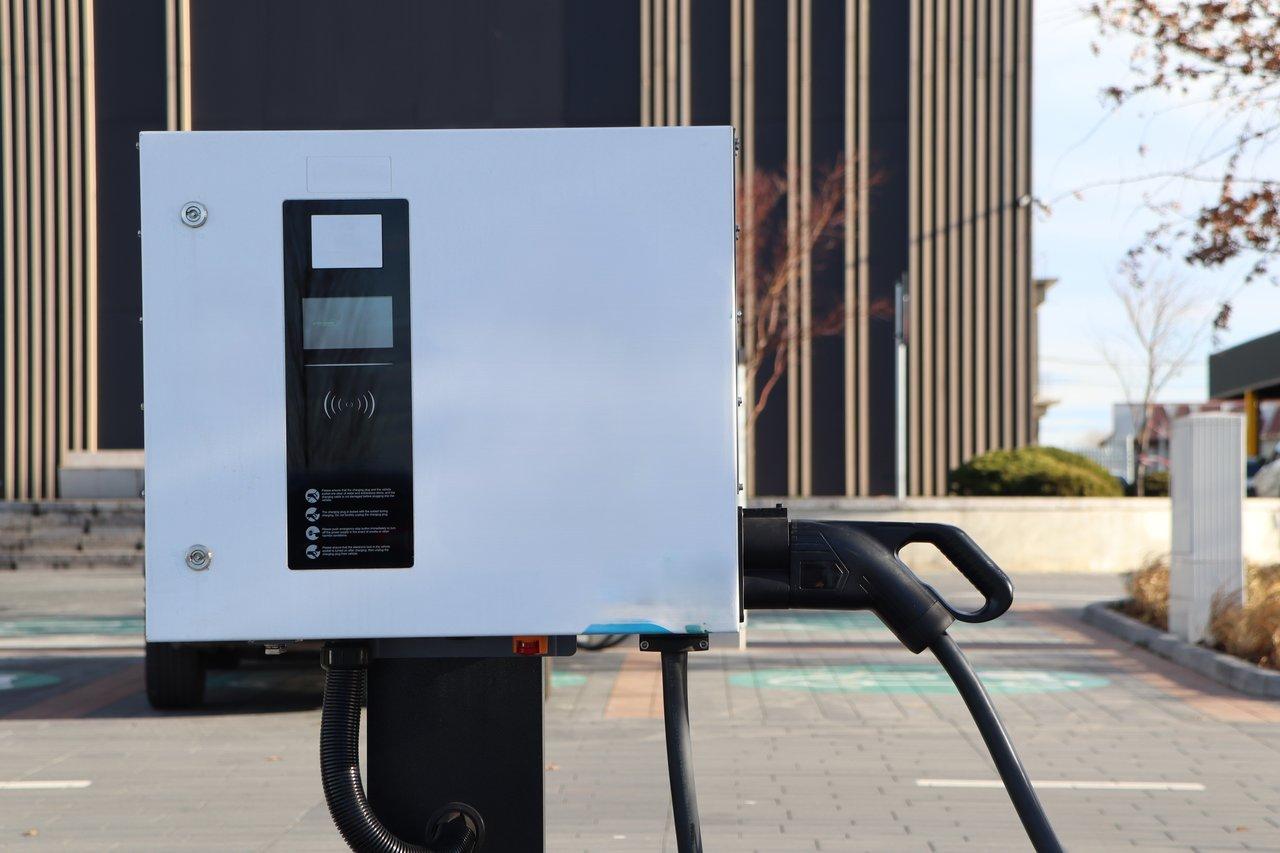 Une borne de recharge rapide électrique moderne en milieu urbain, équipée d'une interface numérique en temps réel.