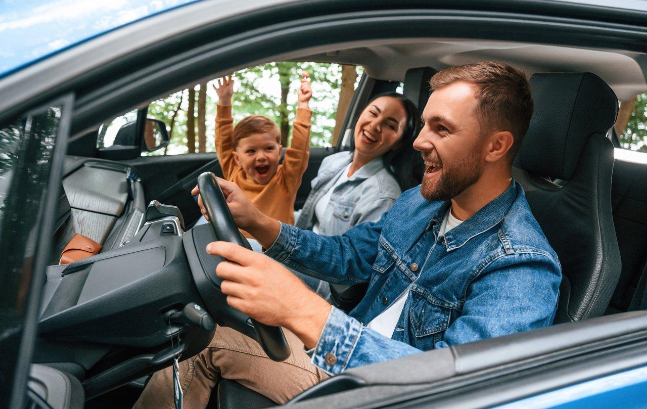 Une famille profitant d’un road trip relaxant à bord d’une modern family sedan sur une route panoramique.