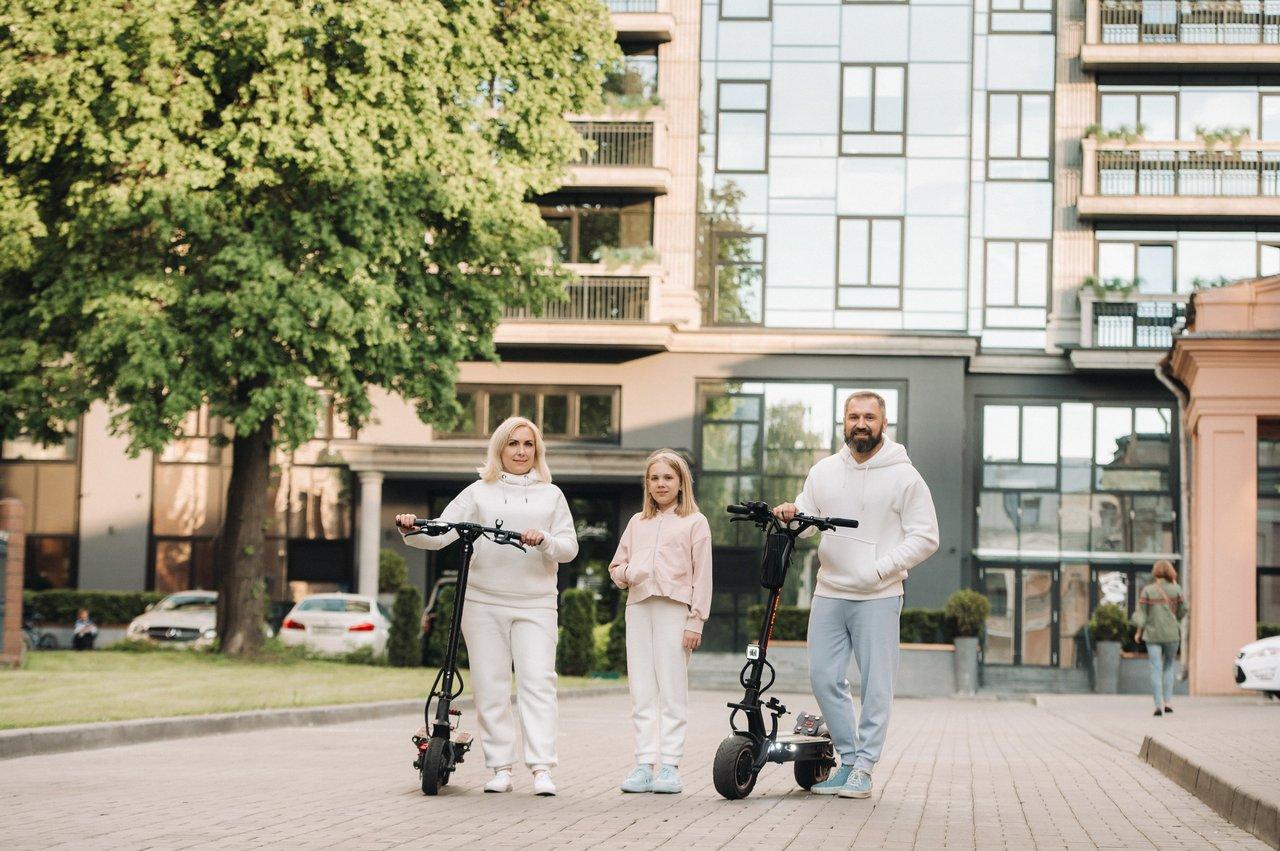 Une famille urbaine privilégie la mobilité douce avec des scooters électriques dans un environnement sécurisé.