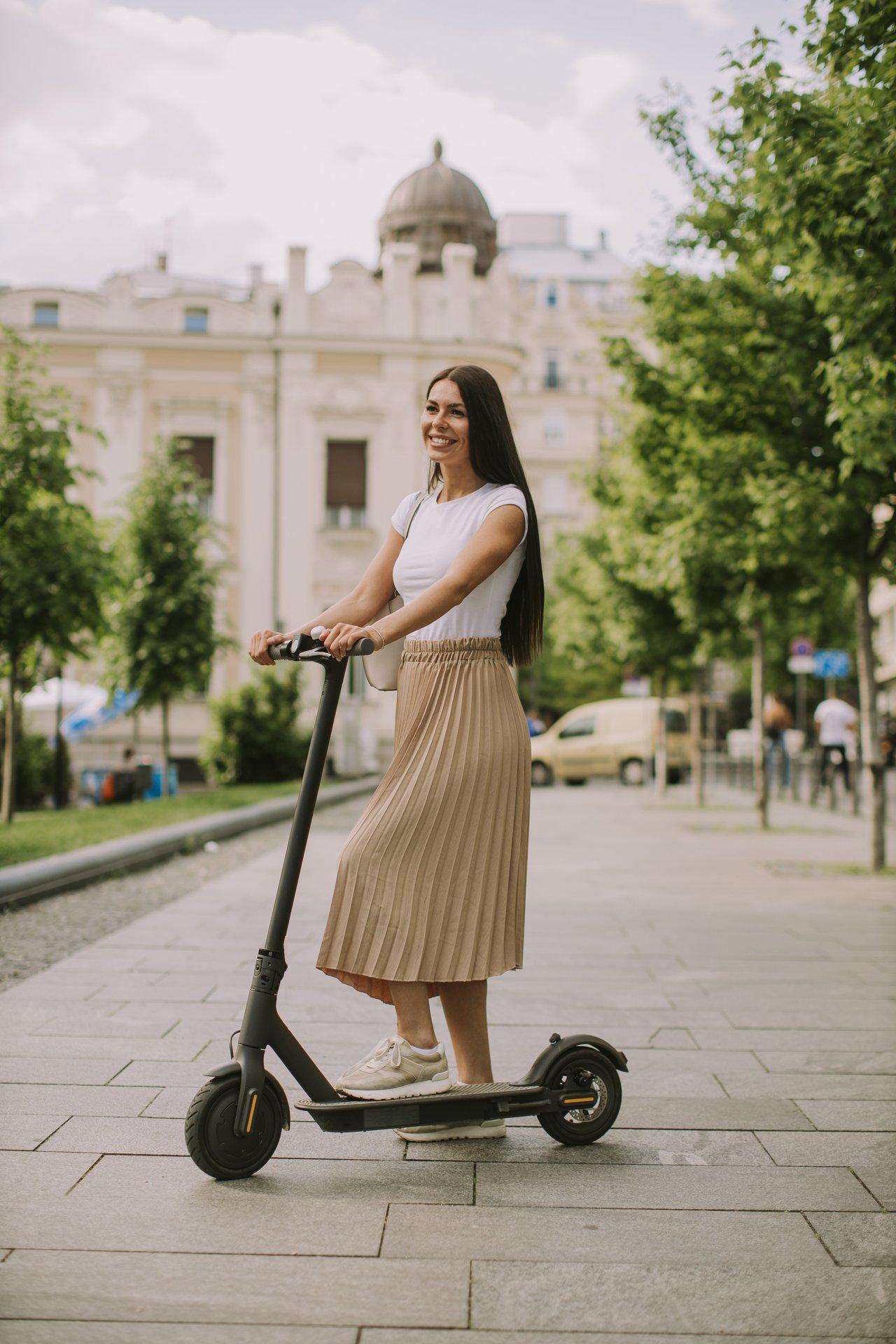 Une femme circule en urban electric scooter dans une zone ZFE, illustrant l'évolution des législations.
