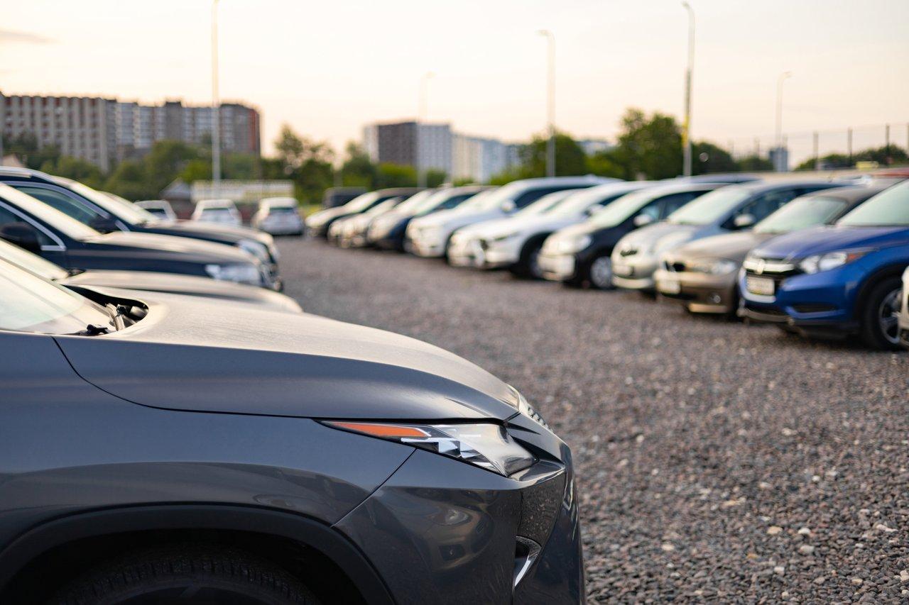 Une rangée de voitures garées en extérieur, illustrant l'importance d'une assurance pour véhicule non roulant.