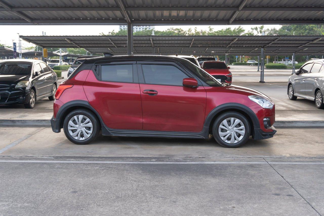 Une red compact city car stationnée aisément dans un espace urbain étroit, idéale pour la mobilité urbaine.