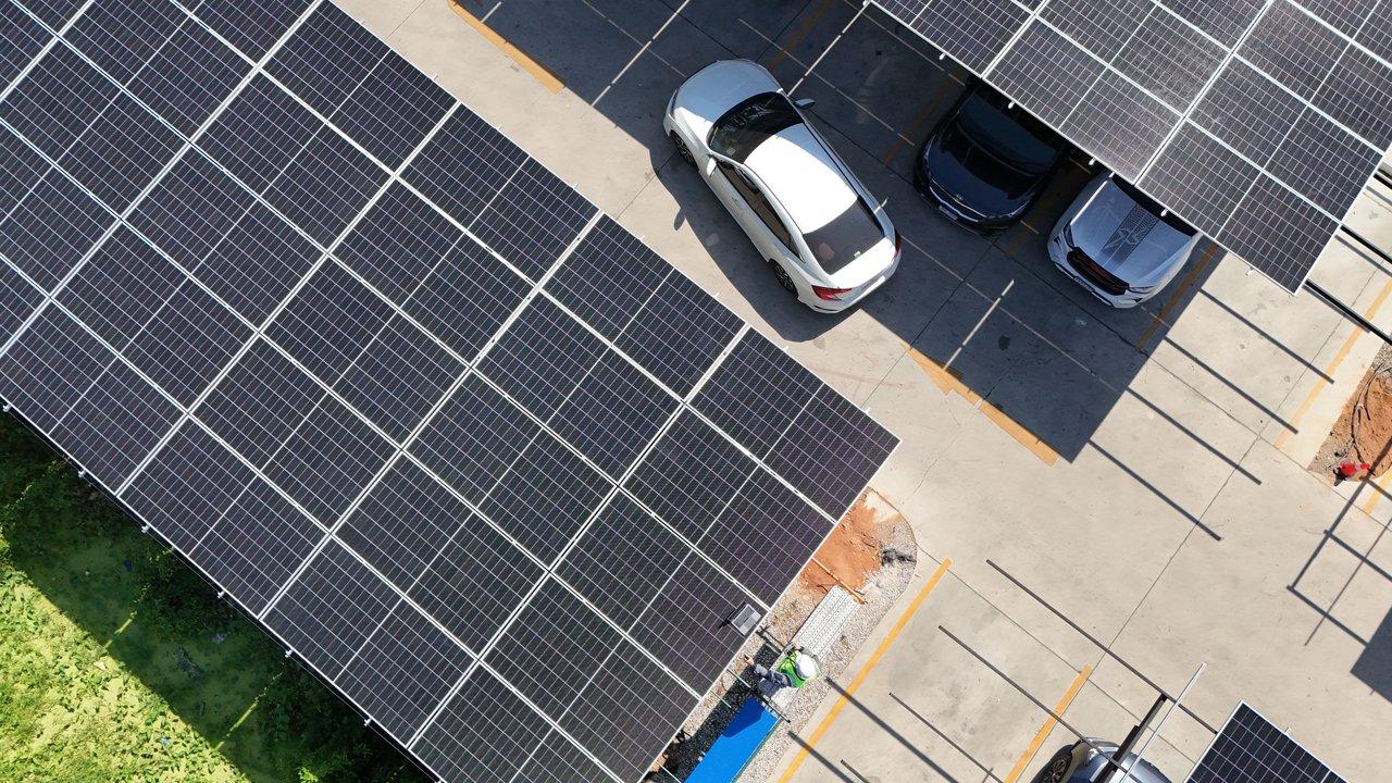 Une voiture hybride rechargeable en ville sous panneaux solaires, symbole d'une mobilité durable et écologique.