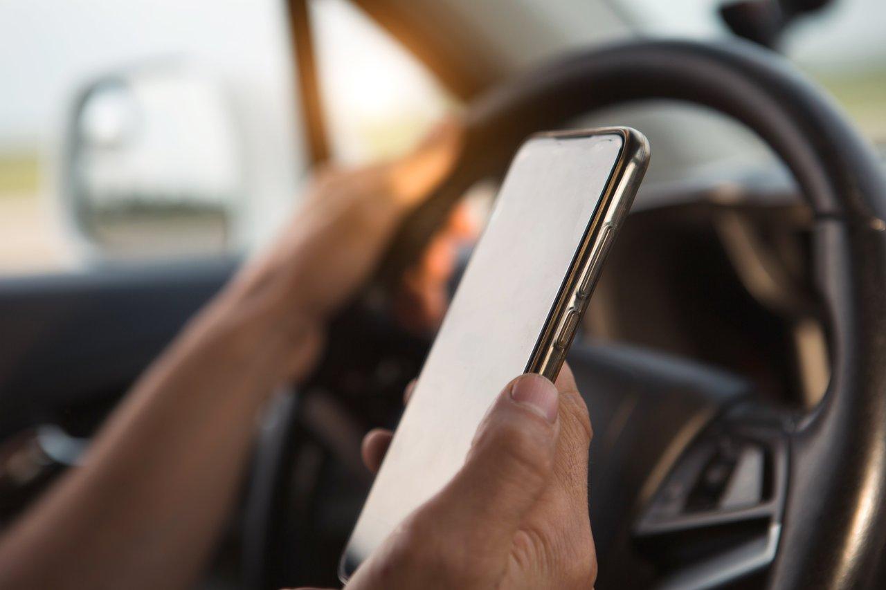 Utilisation du téléphone au volant interdite : un conducteur avec un signe de restriction visible.