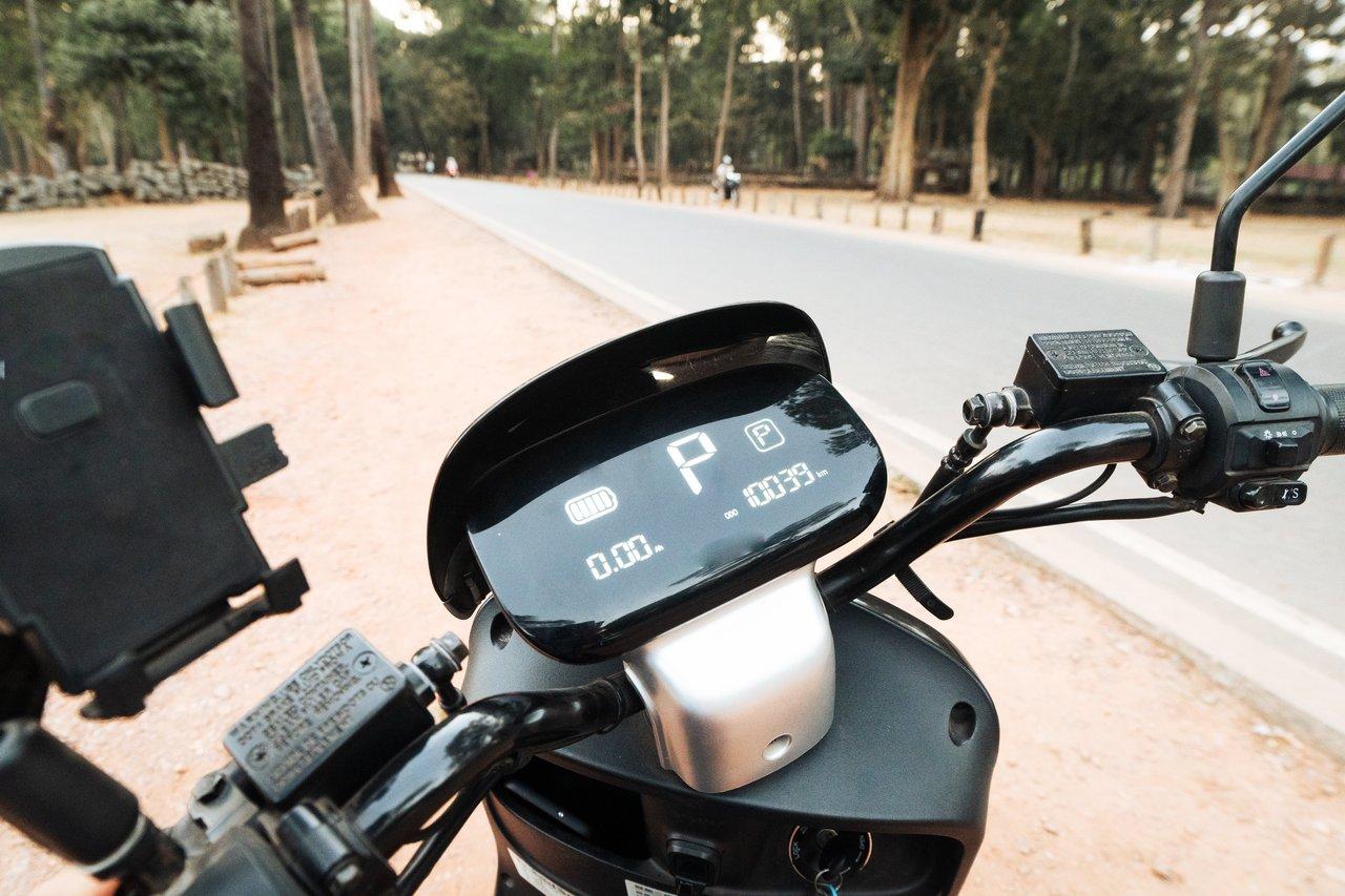 Véhicule électrique hybride pour la ville, affichage numérique sur scooter urbain en environnement moderne.